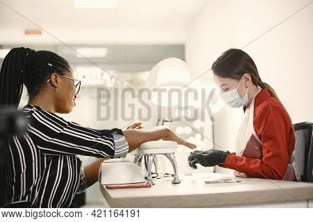 African Girl Doing Manicure In A Beauty Salon