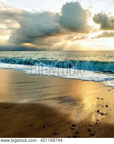 Sun Rays Break Through The Clouds As The Sun Sets On The Ocean Horizon In A Vertical Image Format