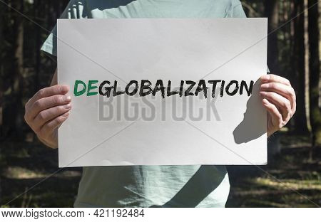 Deglobalization And Reverse Globalization Concept. Word On Paper Placard In Male Hands With Forest B