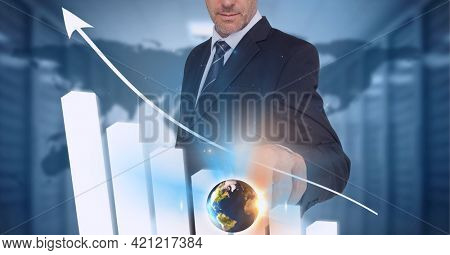Globe and bar graphs over mid section of businessman touching invisible screen against world map. global finance and business technology concept