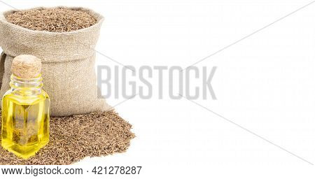Cumin Essential Oil. Glass Bottle Of Cummin Oil. Caraway In A Sack Of Isolated On A White Background