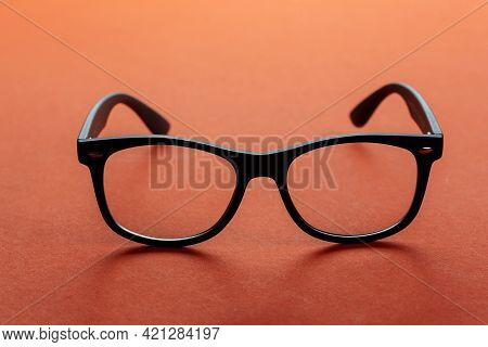 Eyeglasses On Orange Background, Myopia Or Presbyopia.  Eyesight Correction. Fashion Accessories.