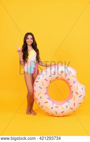 Kid In Swimming Suit With Doughnut Inflatable Ring On Yellow Background, Summer Vacation.