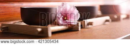 Cup With Sakura Flower For Traditional Tea Ceremony On Wooden Table. Banner Design