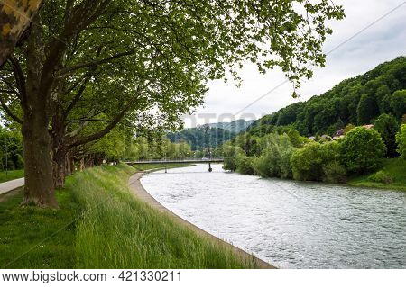 View At The Savinja River With Old Castle On A Hill In The Background In Celje Under Overcast Sky In