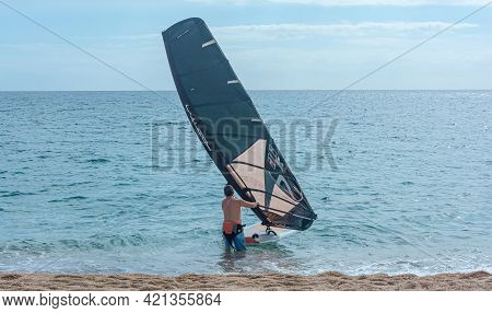 Spain, Tenerife - May 13, 2021: Windsurfing. A Man Is Preparing For A Race On A Board With A Sail. S