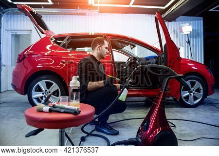 Car Service Worker Cleans Interiror With Special Brush
