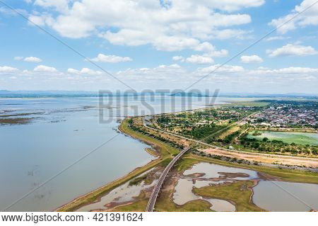Aerial View Of The Railway Bridge Over A Reservoir And Community Near Pasak Chonlasit Dam On Summer 