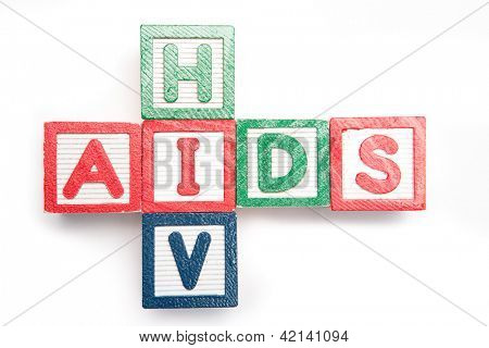 Blocchi di legno ortografia aids e hiv in una forma di croce sul suo lato su sfondo bianco