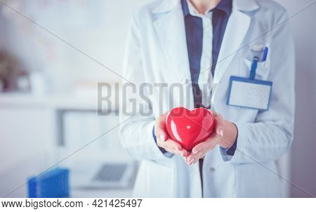 A doctor with stethoscope examining red heart, isolated on white background