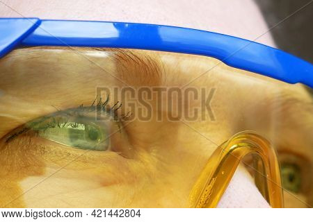 Portrait Of A Woman In Yellow-blue Construction Goggles, A Woman Is A Welder Or An Engineer, Or A Bu