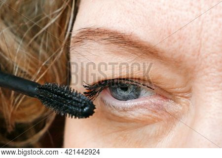 Middle-aged Woman Does Corrective Eye Makeup To Correct The Drooping Eyelid. Ptosis Is A Drooping Of