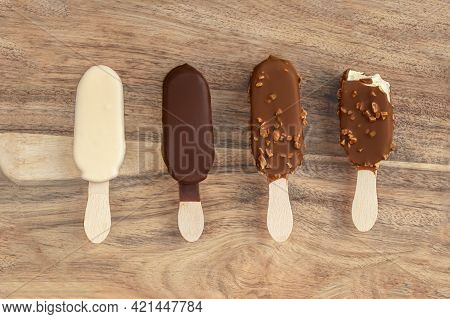 Stick Ice Cream On A Wooden  Background. Vanilla Eskimo Ice-cream Bar. Popsicle And Lolly Sweet Dess