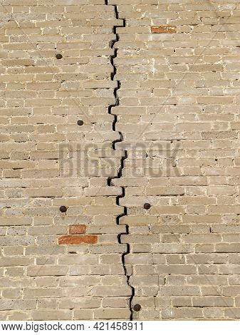 Texture Of An Old Weathered Brick Wall With Big Crack In The Middle Fastened With Rusty Cut Masonry 