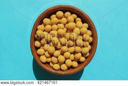 Cheese Coated Salted Peanuts In A Brown Bowl On Bluea Background. Fried Peanut Grains With A Coating