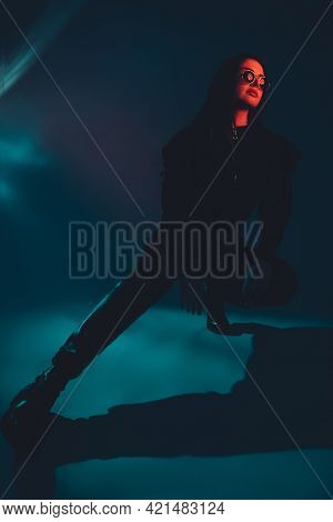 Rock Woman. Grunge Fashion. Cyberpunk Style. Cool Punk Female Model In Black In Sunglasses Sitting O