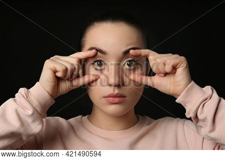 Woman Checking Her Health Condition On Black Background. Yellow Eyes As Symptom Of Problems With Liv