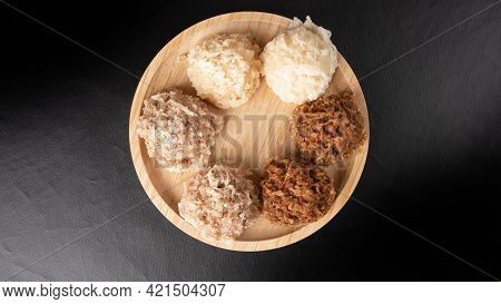 Cocada, Coconut Candy From Brazil, White And Brown Cocadas On Round Wood, Black Background, Top View