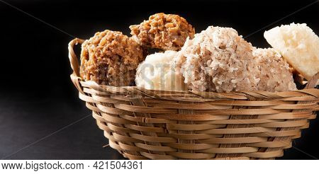 Cocada, Coconut Candy From Brazil, White And Brown Cocadas In A Straw Basket On Dark Surface, Black