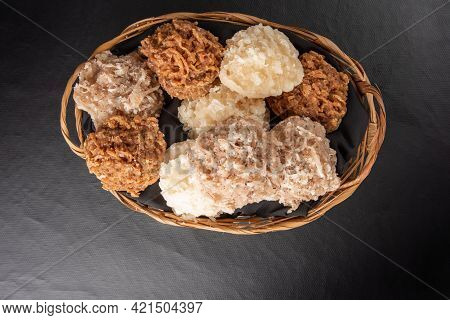 Cocada, Coconut Candy From Brazil, White And Brown Cocadas In A Straw Basket On Dark Surface, Black