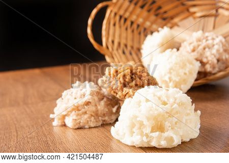 Cocada, Coconut Candy From Brazil, White And Brown Cocadas Fallen From A Straw Basket On Wooden Surf