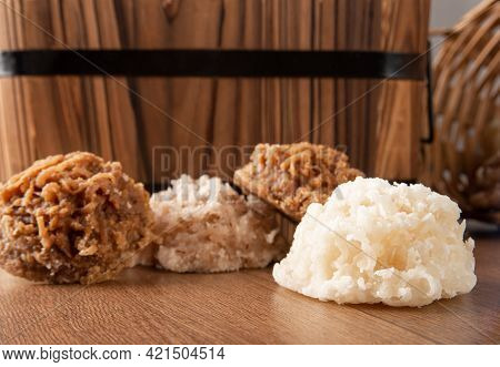 Cocada, Coconut Candy From Brazil, White And Brown Cocadas Fallen From A Straw Basket On Wooden Surf