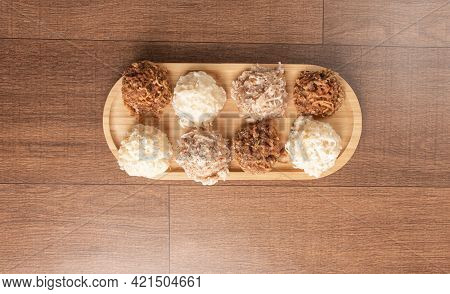 Cocada, Coconut Candy From Brazil, White And Brown Cocadas On Wooden Surface, Black Background, Top