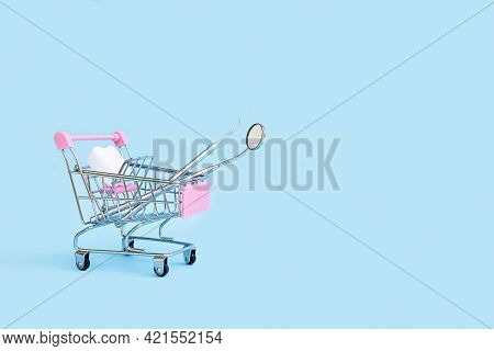 Dental Tools, Mirror And Probe, Fake Tooth Dummy In Shop In Cart Basket Trolley On Blue Background. 