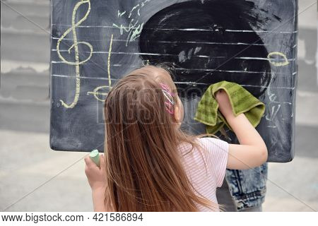 Little Girl Wiping With A Rag A School Board With A Treble Clef Drawn With Chalk Editorial Music Fes