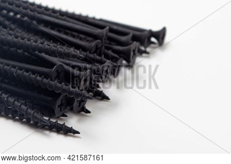 Black Self-tapping Screws On A White Background. Self-tapping Screws For Wood. Construction Consumab