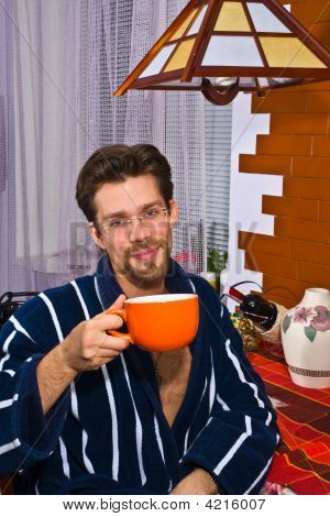 Jovem de manhã em sua cozinha, café da manhã