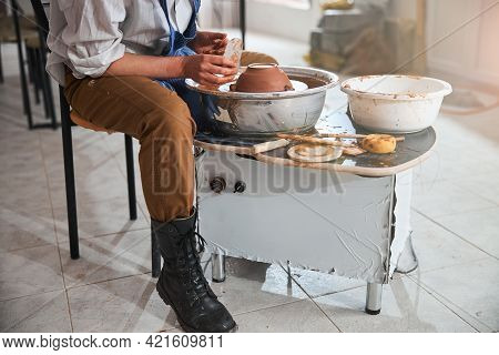 Worker Taking Steel Pottery Scraper For Smoothing Greenware