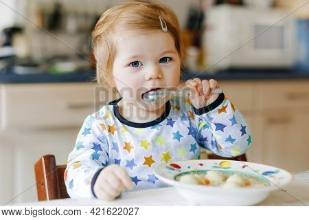 Adorable Baby Girl Eating From Spoon Vegetable Noodle Soup. Food, Child, Feeding And Development Con