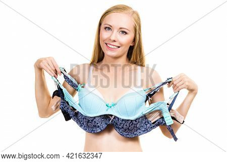 Bosom Concept. Slim Young Woman Wearing Underwear Holding Different Color Bras In Hand, Choosing Whi
