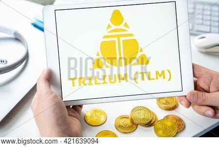 Russia Moscow 05.05.2021. Man Holding Tablet With Logo Of Token Trilium Tlm. Gaming Platform Alien W