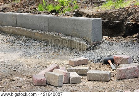 Installation Of Curbstones. Pouring Road Curb With Concrete Before Laying Asphalt.