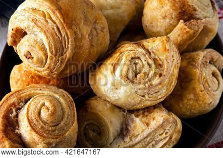 Closeup of fresh homemade puff pastry rolls baked with cinnamon. 