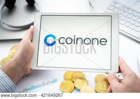 Russia Moscow 06.05.2021.businessman With Tablet.logo Of Cryptocurrency Stock Exchange Coinone.tradi