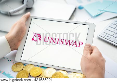 Russia Moscow 06.05.2021.businessman With Tablet.logo Of Cryptocurrency Stock Exchange Uniswap.tradi
