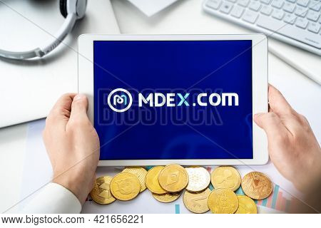 Russia Moscow 06.05.2021.businessman With Tablet.logo Of Cryptocurrency Stock Exchange Mdex.com.trad