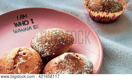 Several Freshly Baked Muffins On A Plate And One Out Of Focus On A Towel