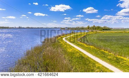 Aerial Springtime Scene Of Dutch River Near Boornzwaag. Cycling Track On Dike Meandering Throug Pold
