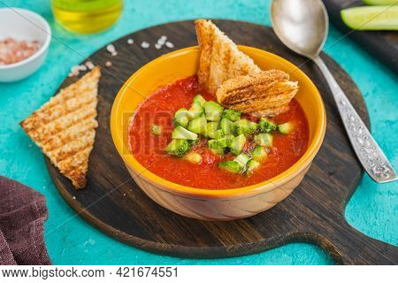 Tomato Gazpacho, Traditional Spanish Cold Soup Or Appetizer In A Yellow Clay Bowl On A Wooden Board 