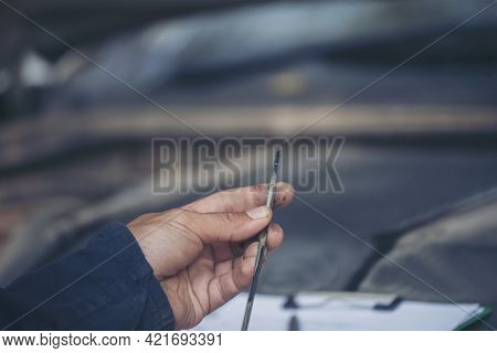 Car Mechanic Man Hand Checking Dipstick Engine Oil Car Mechanical On Site Service. Close Up Hand Man