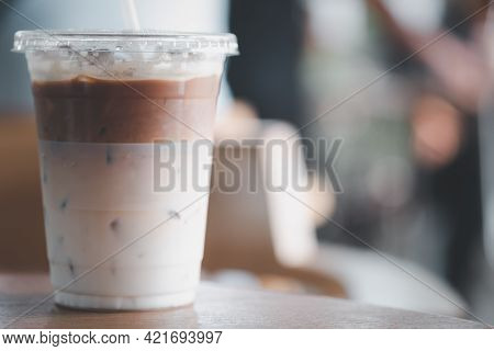 Iced Latte Coffee, The Bottom As Milk Top By Coffee Shot In A Plastic Glass 16oz. On Wood Table