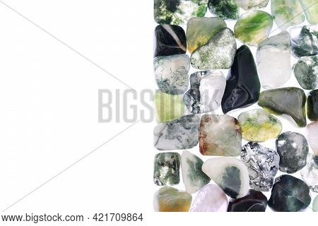 Moss Agate Heap Jewel Stones Texture On Half White Light Isolated Background. Place For Text.
