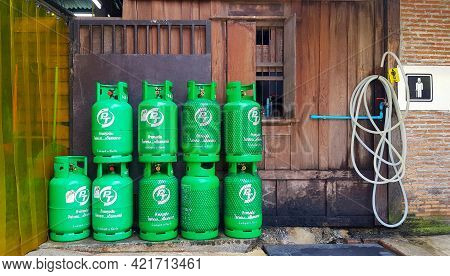ฺbangkok, Thailand - May 5, 2021: Group Of Green Gas Tank With Wooden Background Putting Near Water 