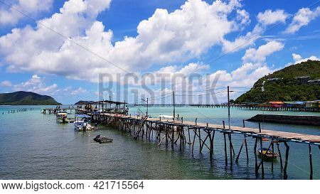 Seascape View. Many Speed Boat Parked At Port With Wooden Bridge Among The Sea And Blue Sky And Whit