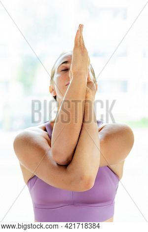 Fitness woman in a Garudasana pose