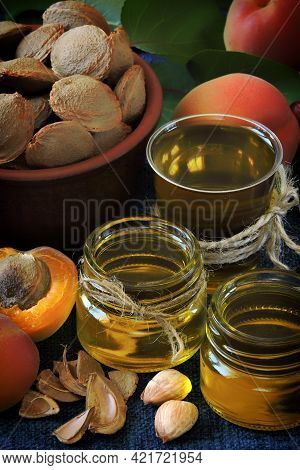 Jars Of Apricot Kernel Oil. Apricots, Leaves, Seeds.